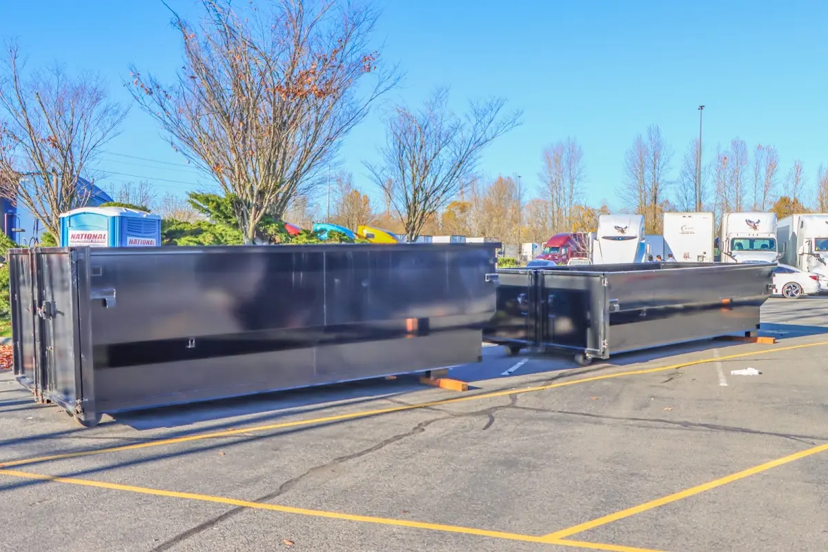 Professional dumpster rental service with roll-off container on residential driveway in Carthage